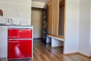 una nevera roja en una cocina con encimera en Aparts ALDEA DEL MONTAÑES en Mina Clavero