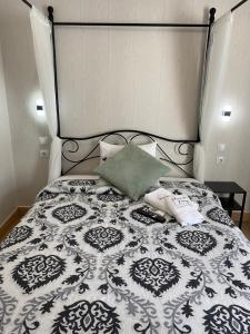 a bed with a black and white quilt and pillows at Charme da Graça in Lisbon