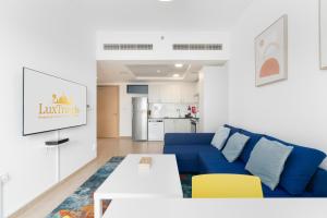 a living room with a blue couch and yellow chairs at Lux BnB Nook -2 I City Views in Dubai