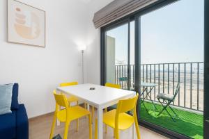 a dining room with a table and chairs and a balcony at Lux BnB Nook -2 I City Views in Dubai