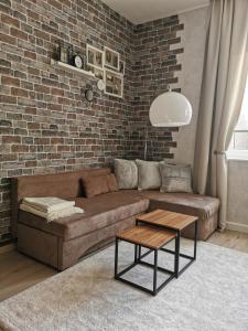 a living room with a brown couch and a brick wall at Ferienwohnung Luise in Naumburg