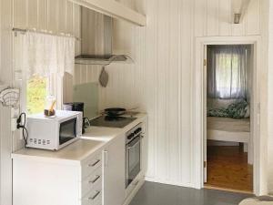 a small kitchen with a microwave and a bedroom at 9 person holiday home in Mosvik-By Traum in Mosvik