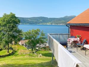 uma casa com um deque com vista para um lago em Holiday home Davik em Davik