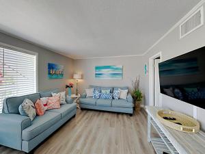 een woonkamer met twee blauwe banken en een tafel bij Sandpiper Cove 2015 in Destin