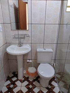 y baño con aseo y lavamanos. en suítes Bomfass, en Alto Paraíso de Goiás