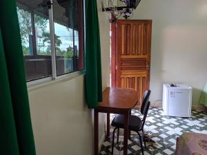 a small table and chair in a room with a window at suítes Bomfass in Alto Paraíso de Goiás +12 photos