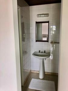 ein Bad mit einem Waschbecken und einem Spiegel in der Unterkunft Hotel Pousada Lord in Teixeira de Freitas