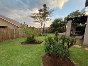 a backyard with two plants in the grass at Le Soleil in Graskop
