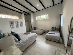 a bedroom with two beds and a couch in it at Le Soleil in Graskop