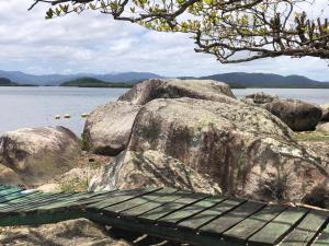 um banco sentado ao lado de algumas rochas grandes em POUSADA CHARMOSA em Superagui