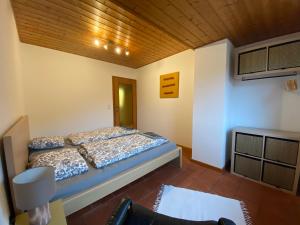 sypialnia z łóżkiem i drewnianym sufitem w obiekcie Ferienwohnung Gangsteig w mieście Grödig