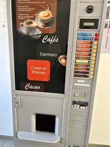 einen Getränkeautomaten mit einer Tasse Kaffee in der Unterkunft Le pont T3 étoilé avec jacuzzi in Saint-Méloir-des-Ondes