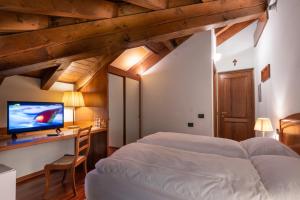 two beds in a room with a desk and a tv at Hotel Roma in Sestola