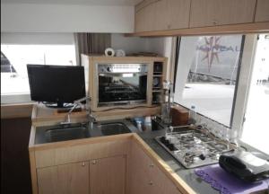 a kitchen with a sink and a stove and a television at יאכטה נעמי in Ashdod