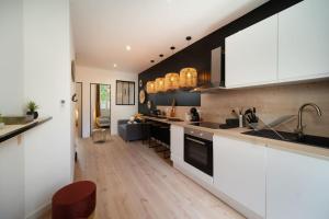 a kitchen with white cabinets and a wooden floor at apartment air conditioning balcony private parking in Marseille