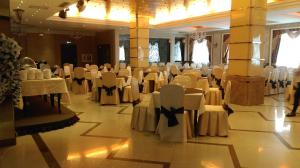 a banquet hall with white chairs and tables in a room at O Azamat in Astana