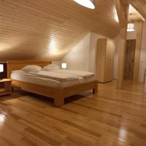 1 dormitorio con 1 cama y suelo de madera en Vila Cedra, en Predeal