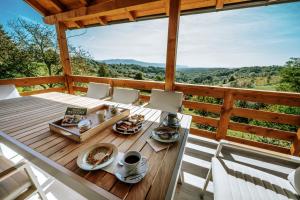 a table on a deck with a view of the mountains at Didov san in Donja Pušća