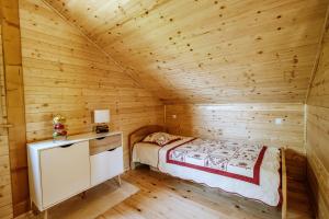 a bedroom in a log cabin with a bed at Didov san in Donja Pušća