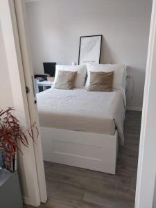 - une chambre avec un lit doté de draps et d'oreillers blancs dans l'établissement Residenza Il Principe Bilocale Centro, à Parme