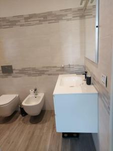 La salle de bains blanche est pourvue d'un lavabo et de toilettes. dans l'établissement Residenza Il Principe Bilocale Centro, à Parme