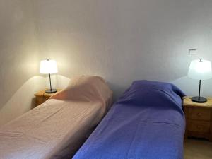 two beds in a room with two lamps on night stands at Appartement Val-d'Isère, 4 pièces, 6 personnes - FR-1-411-714 in Val-d'Isère