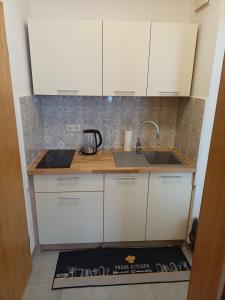 a kitchen with white cabinets and a sink at Apartmán KK in Zwiesel