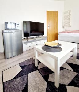 a living room with a white table and a tv at Apartmán KK in Zwiesel