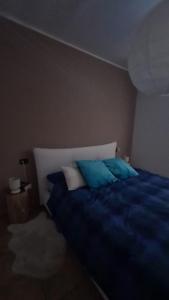 Schlafzimmer mit einem Bett mit blauen und weißen Kissen in der Unterkunft Sasso moro sweet dream in  Monvalle 