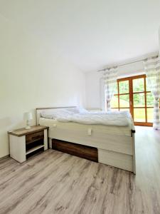 a bedroom with a large bed and a wooden floor at Apartmán KK in Zwiesel