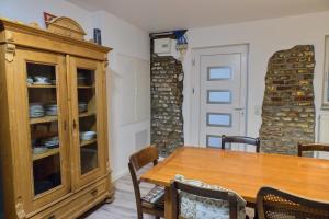 a dining room with a table and a wooden cabinet at Haus Rheinsheimer Scheuer in Philippsburg