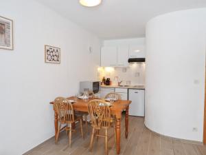 eine Küche und ein Esszimmer mit einem Holztisch und Stühlen in der Unterkunft Appartement Samoëns, 2 pièces, 4 personnes - FR-1-624-125 in Samoëns