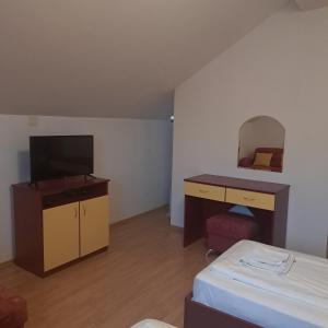 バンスコにあるTodorini Kuli Apartmentsのベッド、デスク、鏡が備わる客室です。
