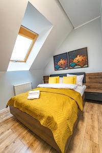 a bedroom with a bed with a yellow bedspread at Apartament w Cieplicach Panorama in Jelenia Góra