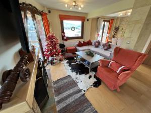 a living room with a couch and a christmas tree at Villa Dream Arachova in Arachova