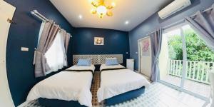 a blue bedroom with a bed and a window at ลิลล์ลดา บูติค โฮเต็ล in Ban Na Oi