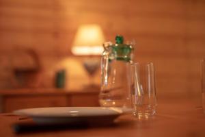 a table with a bottle and two glasses on it at guesthome la petite salette in Monestier-de-Clermont