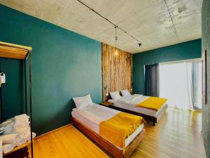 a bedroom with two beds and a green wall at Hotel Misty Mountain in Kazbegi