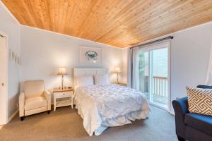 a bedroom with a bed and a wooden ceiling at The Salty Salmon - Meredith Lodging in Rockaway Beach +63 photos