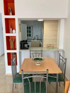 a dining room table with chairs and a kitchen at Apartamento Marina in Puerto del Carmen