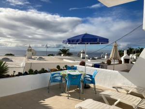 a patio with a table and chairs and an umbrella at Apartamento Marina in Puerto del Carmen