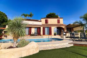 a villa with a swimming pool in front of a house at La Demeure Insoupçonnée in Cassis