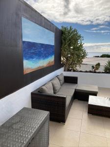 a patio with a couch and a painting on a wall at Apartamento Marina in Puerto del Carmen