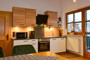 a kitchen with white cabinets and a stove top oven at Bodenmaiser Herz-Hoamad Ferienwohnung Bierl in Bodenmais