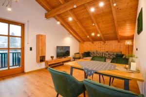 ein Wohnzimmer mit einem Tisch, Stühlen und einem Sofa in der Unterkunft Bodenmaiser Herz-Hoamad Ferienwohnung Bierl in Bodenmais