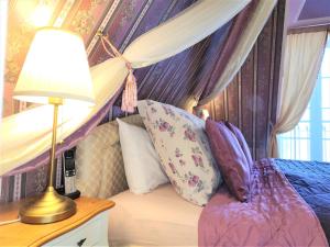 a bedroom with a canopy bed with a lamp and pillows at Rezidence Zámeček - Boutique Hotel in Františkovy Lázně