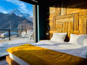 a bedroom with a bed with a view of a mountain at Hotel Misty Mountain in Kazbegi