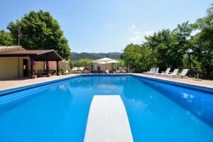 une grande piscine bleue avec des chaises et un kiosque dans l'établissement Villa Santa Maria Deruta, à Deruta