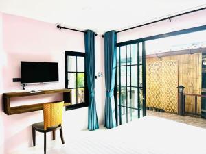 a bedroom with a desk and a tv and a window at Baan Purada in Ko Lanta +45 photos