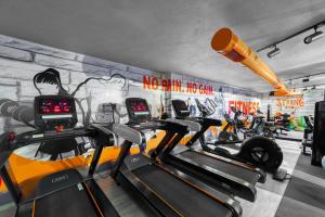 a gym with several treadmills and a wall with graffiti at Aria Riva Apart Hotel in Alanya